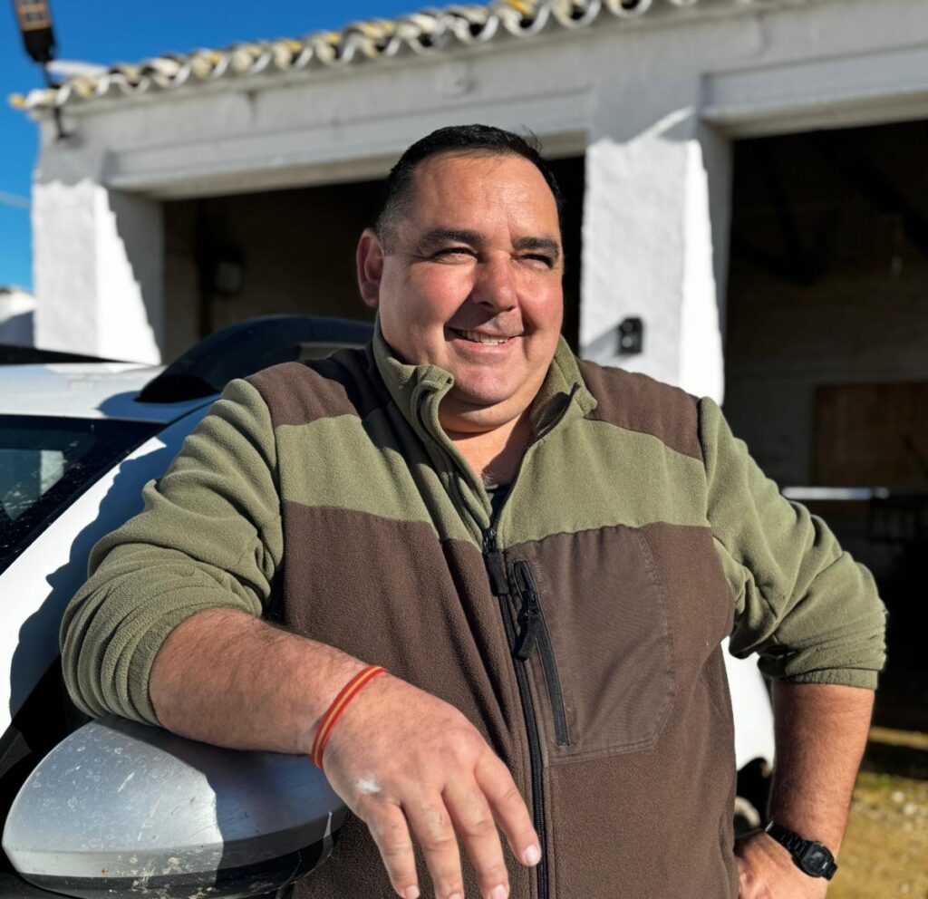 Francisco Gómez, hidekeeper en El Taray, posando para cámara apoyado en el retrovisor del coche de empresa